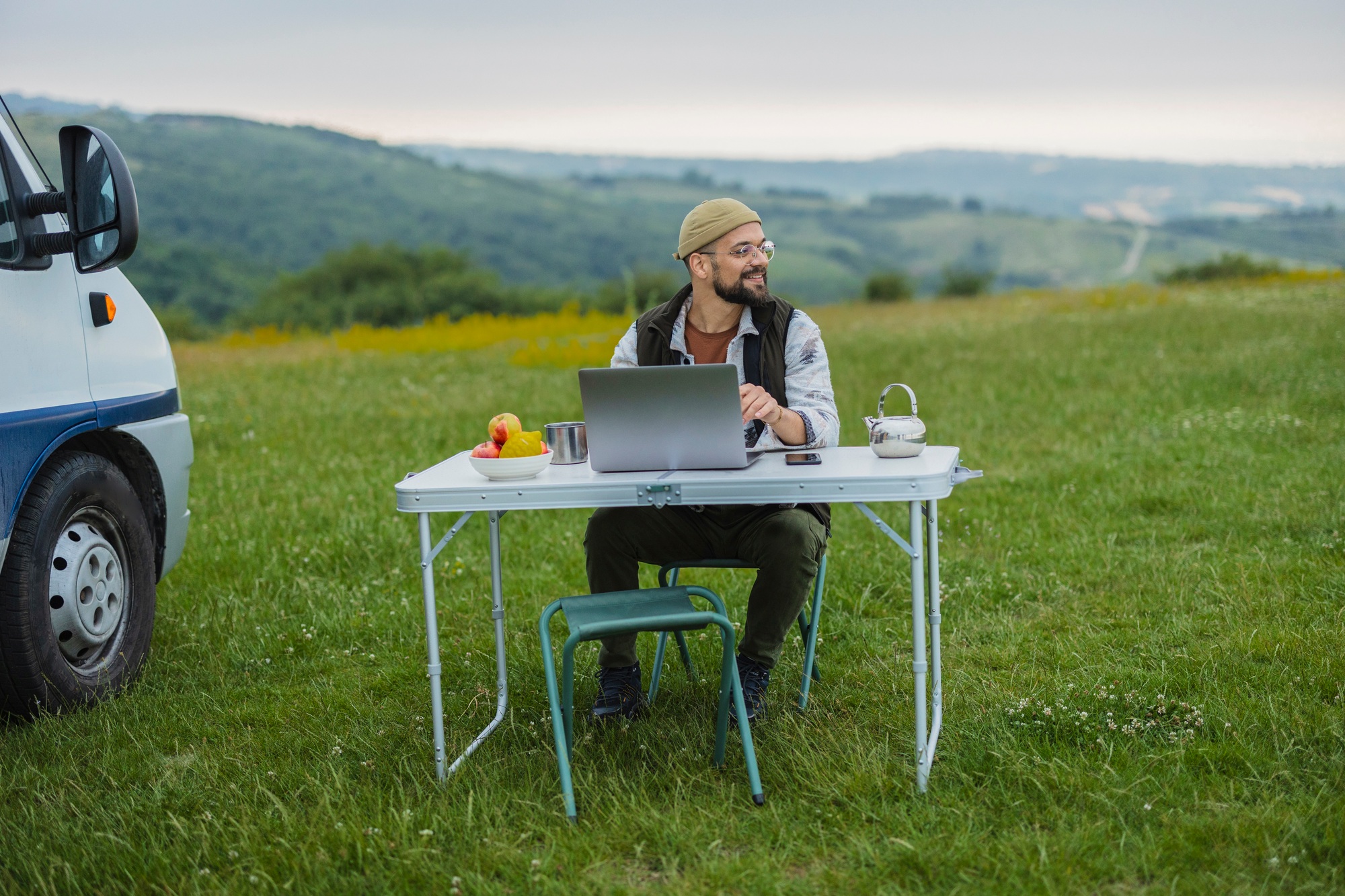 Man working remotely on laptop during outdoor camping trip
