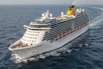 Grand paquebot MSC Croisières naviguant en pleine mer, vue aérienne latérale montrant les multiples ponts et le pont arrière